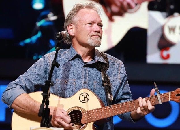 John Berry on stage with a guitar